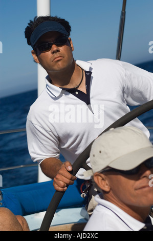 Mann am Ruder der Segelboot am Ozean Stockfoto