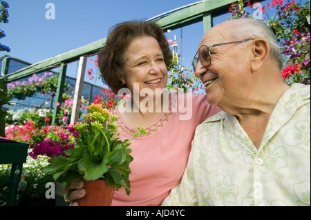 Senior paar sitzen unter Blumen Gärtnerei, Nahaufnahme Stockfoto