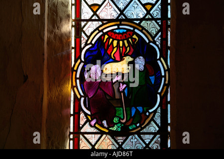 Glasfenster mit der Darstellung von Abraham, das in der St Botolphs Church, Hardham, West Sussex, England, ein Opferlamm für Gott anbietet Stockfoto