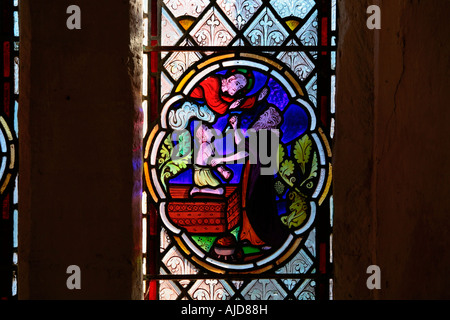 Glasfenster mit der Darstellung von Abraham, der seinen Sohn Isaac als Opfer für Gott in der St Botolphs Church in Hardham, West Sussex, aufopferte. Stockfoto