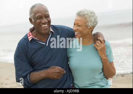 Älteres paar umarmt am Strand Stockfoto