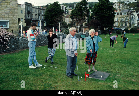 Bank Holiday Maker spielen Minigolf am Meer. Stockfoto