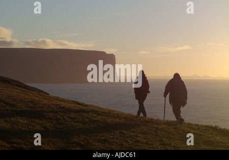 dh SCHWARZ CRAIG ORKNEY Dämmerung Sonnenuntergang weibliche Wanderer Frauen zu Fuß Outdoor Spaziergang Landschaft uk Herbst Küste Meer zwei Wanderer Wandern Silhouette verbinden Stockfoto