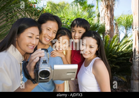 Familie Looking at Videokamera Bildschirm im Hinterhof, Vorderansicht Stockfoto