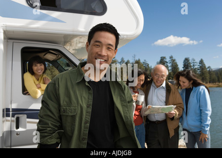 Mann stand vor RV am See mit der Familie hinter Stockfoto