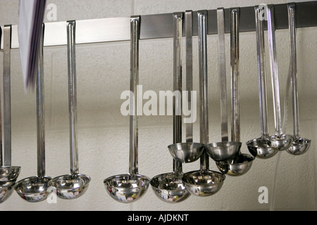 Verschiedene Größe Schöpfkellen hängend Rack in Schulküche Stockfoto