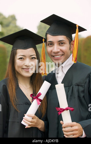 Zwei Absolventen hält Diplome draußen, Porträt Stockfoto