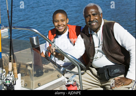 Großvater und Enkel sitzen auf Fischerboot (Hochformat) Stockfoto