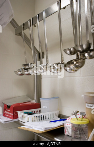 Verschiedene Größe Schöpfkellen hängend Rack in Schulküche Stockfoto