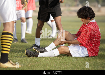 Verletzten Fußballspieler sitzen auf Tonhöhe, Porträt Stockfoto