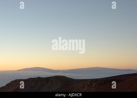 Sunrise (Sonnenaufgang) auf dem Gipfel des Haleakala Vulkan Nationalparks, Maui, Hawaii, mit Big Island in der Ferne Stockfoto