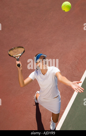 Frau am Tennisplatz dienen Tennisball, erhöhten Blick Stockfoto