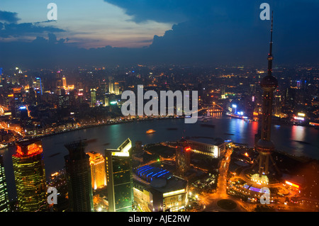 Der Oriental Pearl Tower in Pudong und beleuchteten Gebäuden auf den Bund am Ufer des Huangpu River in Shanghai Stockfoto