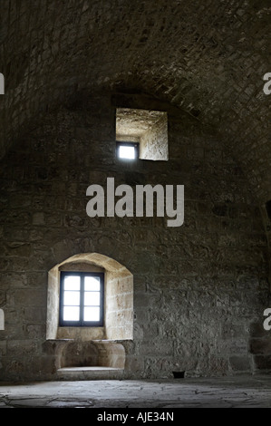 Mittelalterliche Burg Kolossi Interieur mit gewölbter Decke und Licht, das durch zwei Fenster in einer Steinmauer in Zypern Stockfoto