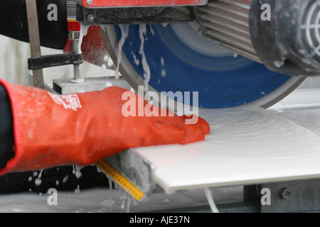 Arbeiter zum Schluss eine Kachel in Hälfte Sägen Stockfoto