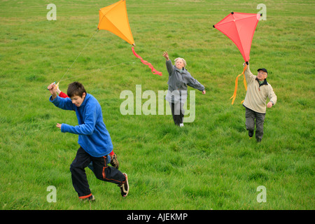 Großeltern und ihre Enkel sind Drachen zusammen fliegen. Stockfoto