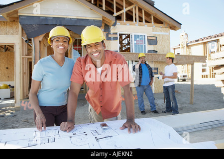 Paar auf der Suche auf Blaupausen des neuen Hauses Stockfoto