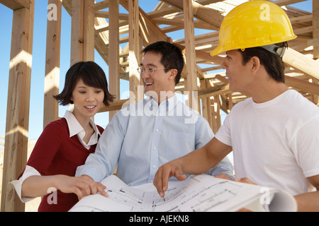 Paar auf der Suche auf Blaupausen mit Generator Stockfoto