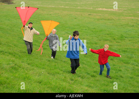 Großeltern und ihre Enkel sind Drachen zusammen fliegen. Stockfoto