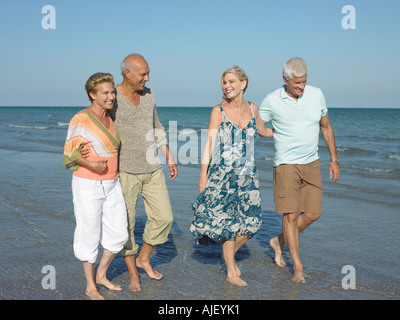 Zwei ältere Ehepaare, barfuß am Strand Stockfoto