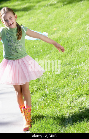 Mädchen tragen Feenflügel und Tutu Balanceakt am Rand des Weges, Porträt Stockfoto