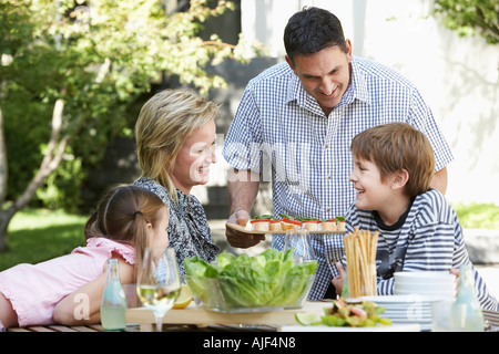 Vierköpfige Familie, die Mittagessen im Freien, Porträt Stockfoto
