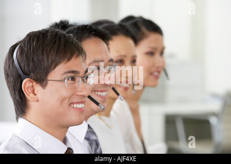 Zeile der Kundendienstmitarbeiter Telefon-Headsets in Büro, Kopf und Schultern tragen Stockfoto