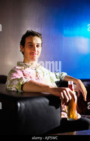 Mid-Adult Mann sitzt in stilvoller Stuhl, halten Bier, portrait Stockfoto