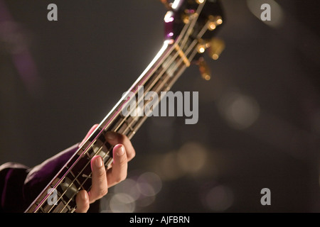 Junger Mann, Bass-Gitarre auf der Bühne spielen Stockfoto