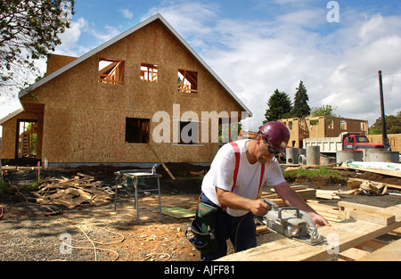 Bau Arbeiter Schneiden von Holz auf dem Gelände eine Wohnsiedlung Stockfoto