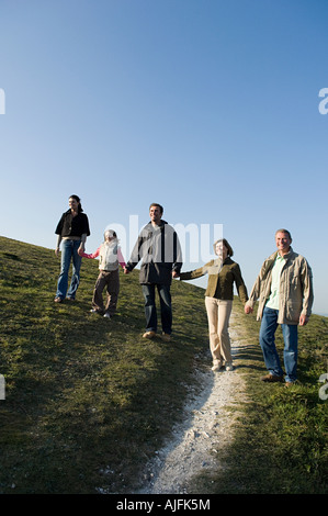 Familie gehen Hand in Hand auf Hügel Stockfoto