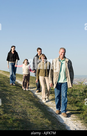 Familie gehen auf grasbewachsenen Hügel Stockfoto