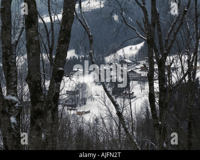Französische Alpen in Megeve Frankreich Blick durch Bäume am Straßenrand seitlich. Eine Schneelandschaft, die am Straßenrand auf Weg nach Megeve Ski resort Stockfoto