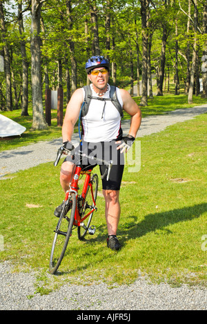 Mann in vollen Zyklus Kleidung inklusive Helm und Brille auf seinem Rennrad Stockfoto