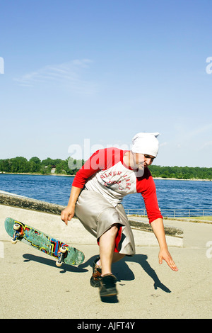 Männliche Teenage Praktiken springt Tricks und Maneouvers auf einem skateboard Stockfoto