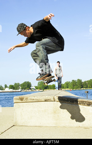 Männliche Teenage Praktiken springt Tricks und Maneouvers auf einem skateboard Stockfoto