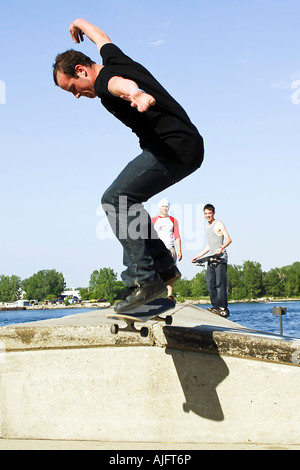 Männliche Teenage Praktiken springt Tricks und Maneouvers auf einem skateboard Stockfoto