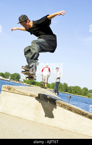 Männliche Teenage Praktiken springt Tricks und Maneouvers auf einem skateboard Stockfoto