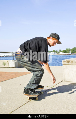 Männliche Teenage Praktiken springt Tricks und Maneouvers auf einem skateboard Stockfoto