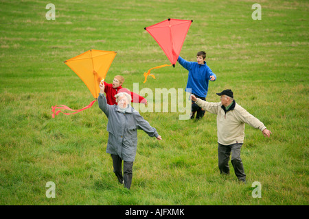 Großeltern und ihre Enkel sind Drachen zusammen fliegen. Stockfoto