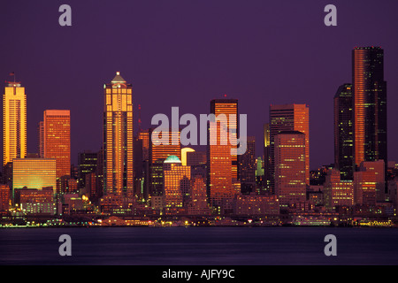 Mond steigt zwischen Downtown Seattle Washington Skyline bei Sonnenuntergang Blick von West Seattle über Elliot Bay Wolkenkratzer Stockfoto