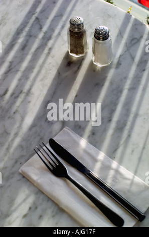 Tisch im Restaurant noch Leben mit Geschirr Salz Pfeffer am späten Nachmittag Beleuchtung mit Schatten Stockfoto