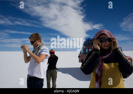 Touristen bewundern die riesigen Salar de Uyuni Stockfoto