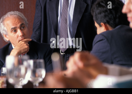 Senior und Junior Führungskräfte rund um den Konferenztisch zu einem business Meeting Stockfoto
