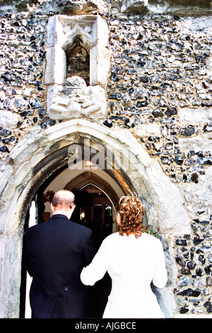 Braut geht mit ihrem Vater in Kirche. Stockfoto