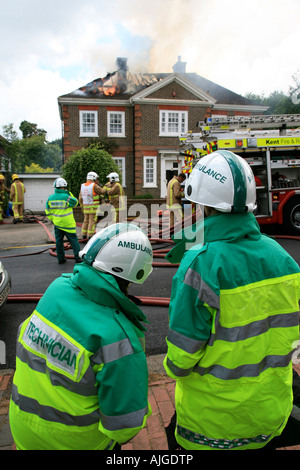 Schüler und Krankenwagen Männer beobachten Feuerwehr Feuerwehr und eine Housefire in Tunbridge Wells Kent England vereint Ki Außerbetriebnahme Stockfoto