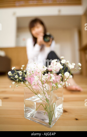 Junge Frau nehmen Fotos von Blumen Stockfoto