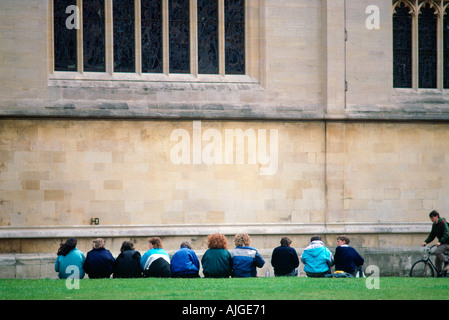 Eine Aufstellung der Studenten draußen sitzen und aufwendige Stein Ivy League Gebäude auf dem Campus Gebäude tragen winter Jacken Stockfoto