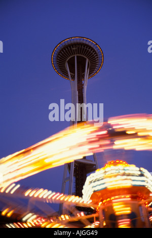 Carnival Ride Lichter machen unscharfe Ring um die Basis des Seattle Space Needle Wahrzeichen Seattle Center Seattle Washington USA Stockfoto