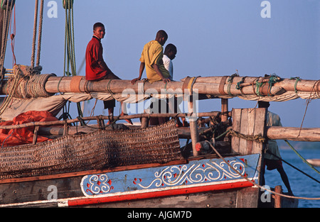 Fischer sitzend am Mast der ihre Dhau Stone Town Dhau-Hafen bei Sonnenuntergang Unguja Sansibar Tansania Stockfoto